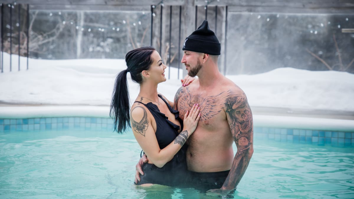 Young couple in bathing suits in the outdoor pool in winter at the AX Hotel in Tremblant.