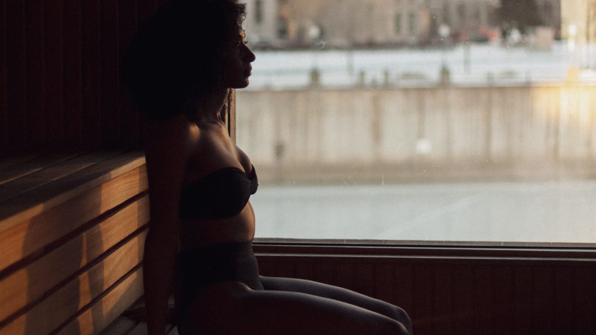 Woman in the sauna looking out over the Old Port of Montreal.