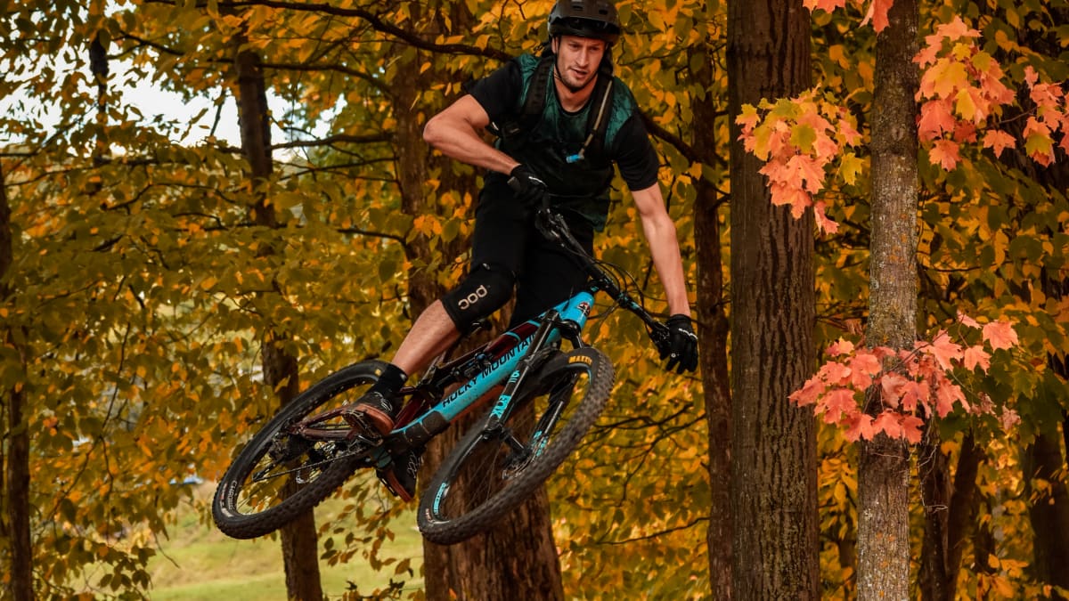Mountain biker making a jump in a fall setting.