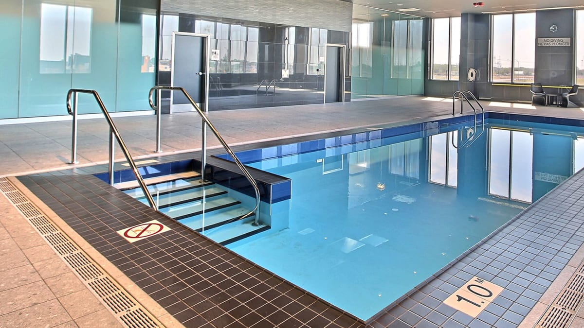 Piscine intérieure de l'hôtel dans une salle vitrée.
