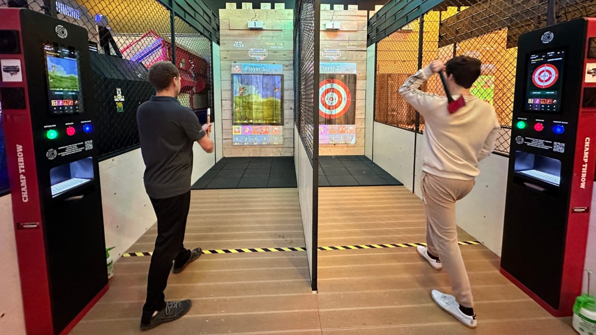 Two men taking part in an axe-throwing activity.