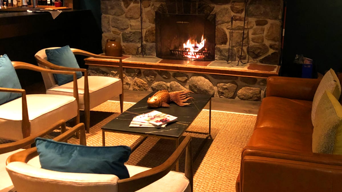 Lounge, bar, feu de foyer et sofas au Domaine Jolivent.