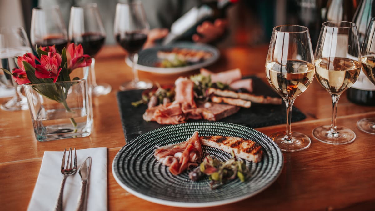 Tasting experience with multiple glasses of wine and a plate of food.