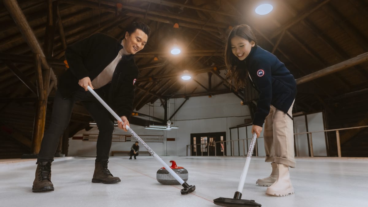Deux personnes en train de jouer au curling.