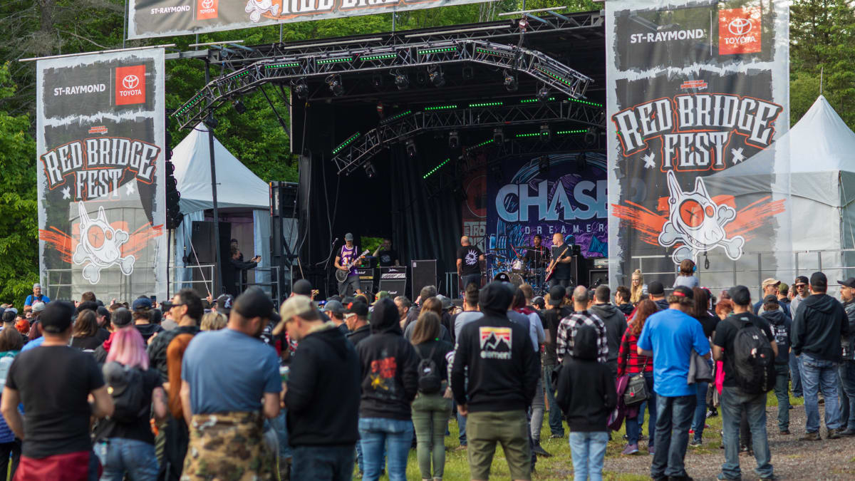 Crowd in front of a festival stage during the day.