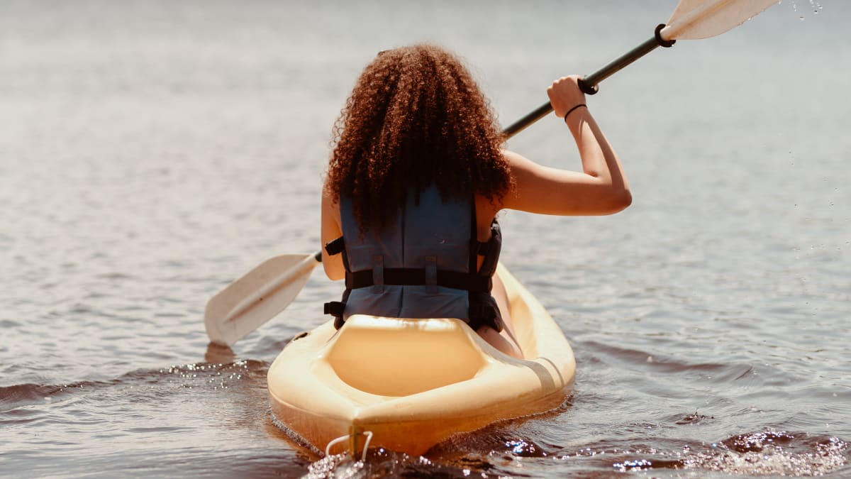 Jeune femme en kayak sur le lac. Young woman in a kayak on the lake.