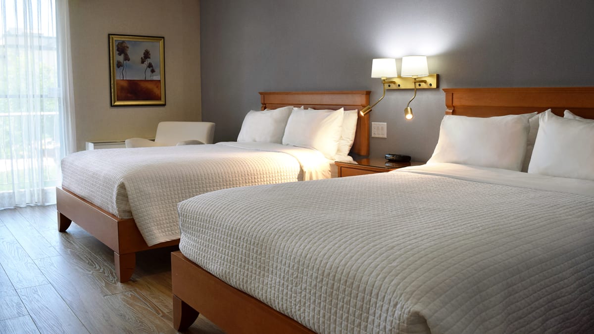 Room with two large beds at Hôtel Castel.