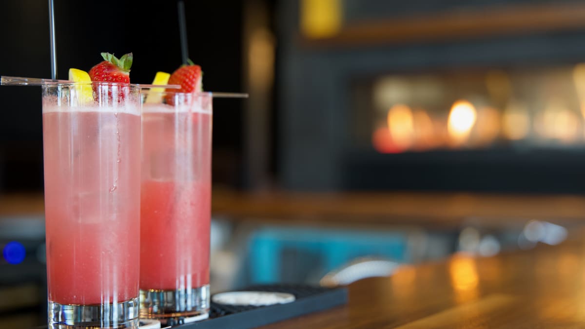 Two fruity cocktails on a counter at a resto-bar