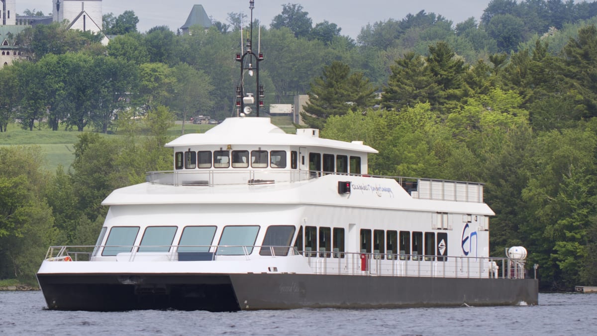 Cruise ship on a lake. There is an abbey in the background.