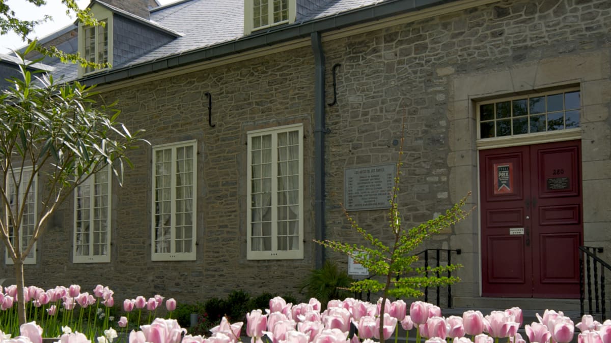 Extérieur d’un musée aux murs en pierre; autour, le sol est couvert de tulipes.