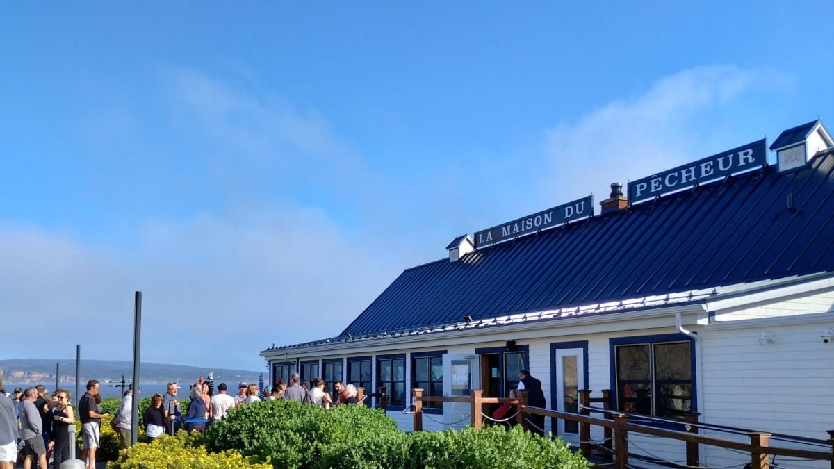 People lining up outside a restaurant called La Maison du Pêcheur.