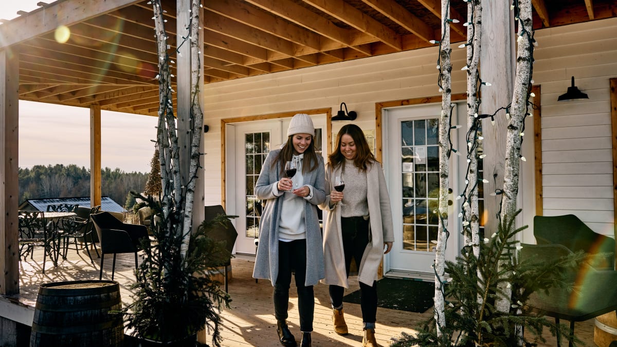 Deux jeunes femmes à l'extérieur d'une boutique sur la propriété d'un vignoble en hiver.