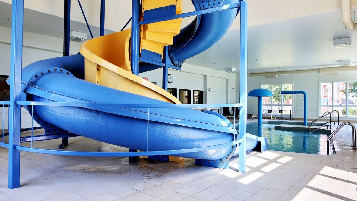 Indoor pool with blue and yellow slide at Super 8 Lachenaie.