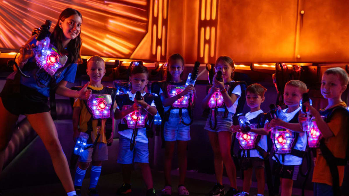 Monitrice avec sept jeunes enfants vêtus de gilets illuminés.