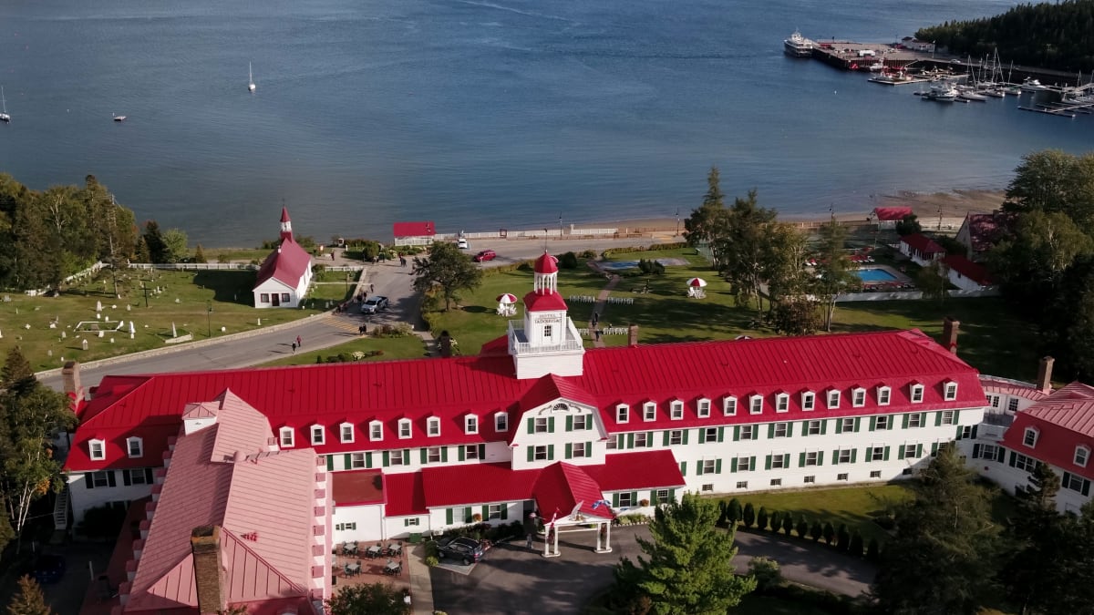 Aerial view of a red-roofed waterfront hotel.