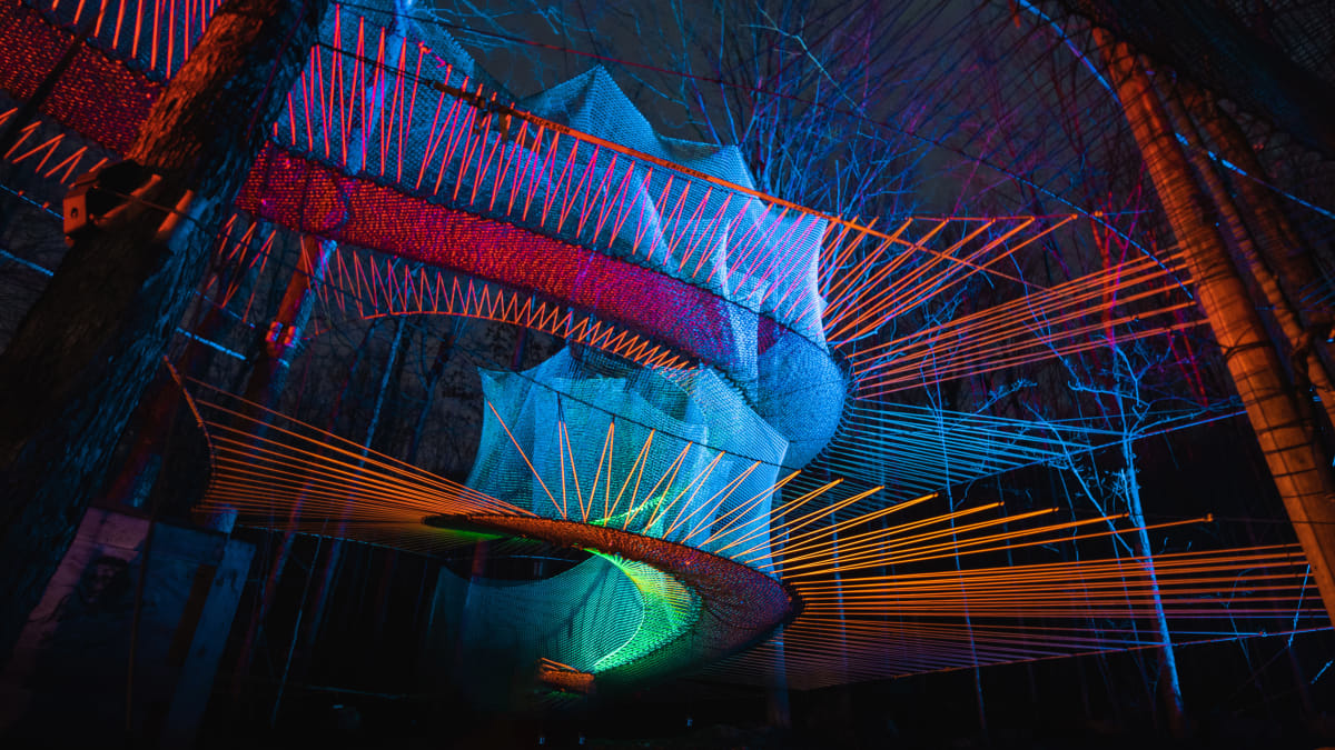 Illuminated trampolines at Upla at night.
