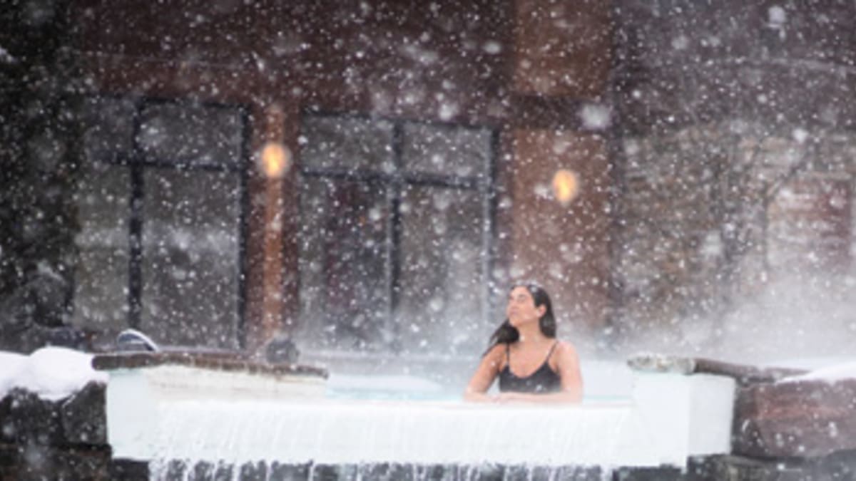 Woman in a thermal pool under the snowflakes