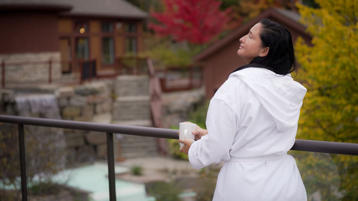 Femme en robe de spa sur le bord des installations thermales.