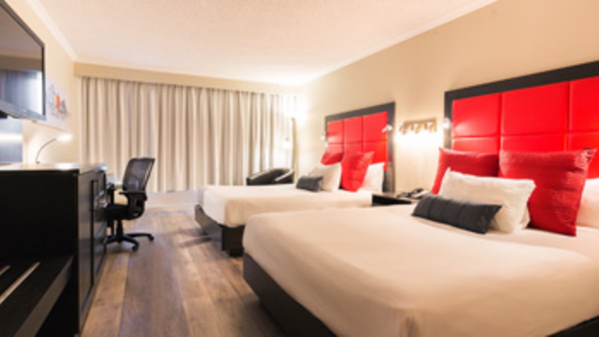 Intérieur d’une chambre d’hôtel aux accents rouges avec deux grands lits