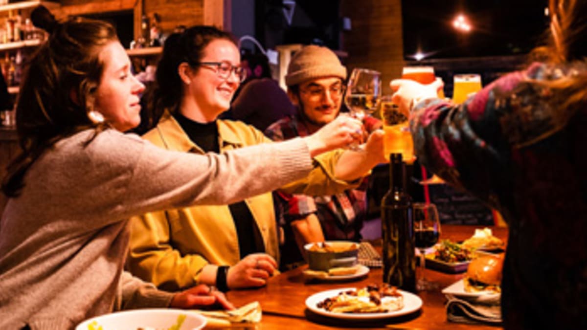 Groupe d’amis autour d’une table en train de porter un toast