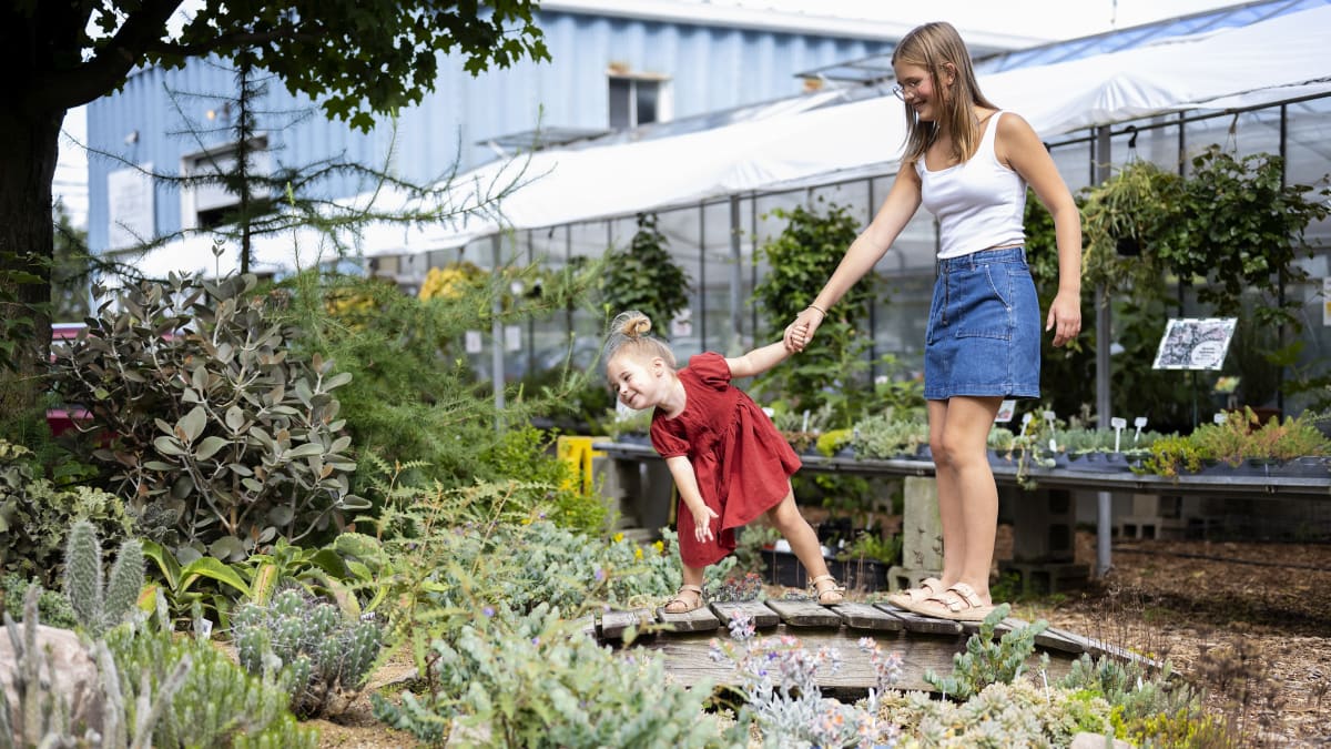 Mother and young daughter in front of a garden of cactuses.