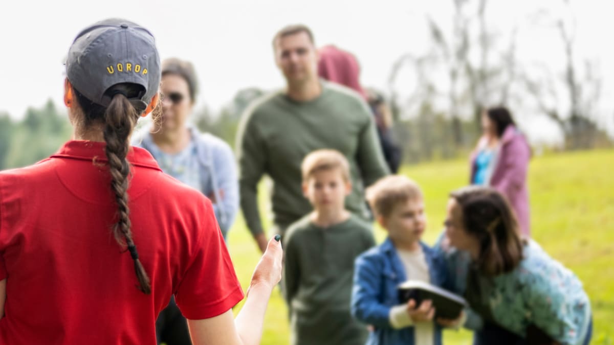 Guide giving a presentation with an owl in front of a few people.