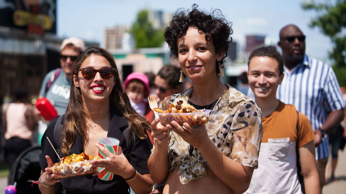 Two festival-goers with street food in hand.