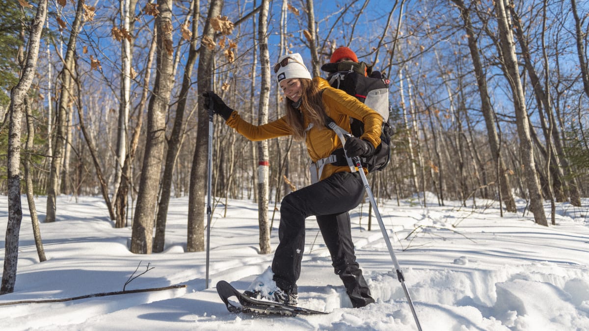 Young mother and baby on a snowshoeing trail