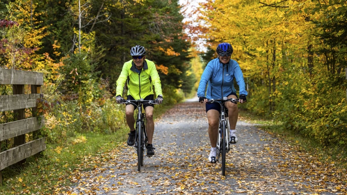 Couple on bicycles at Station touristique Duchesnay in the fall.