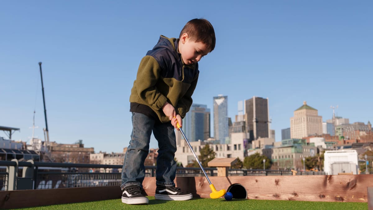 Young boy playing mini-putt