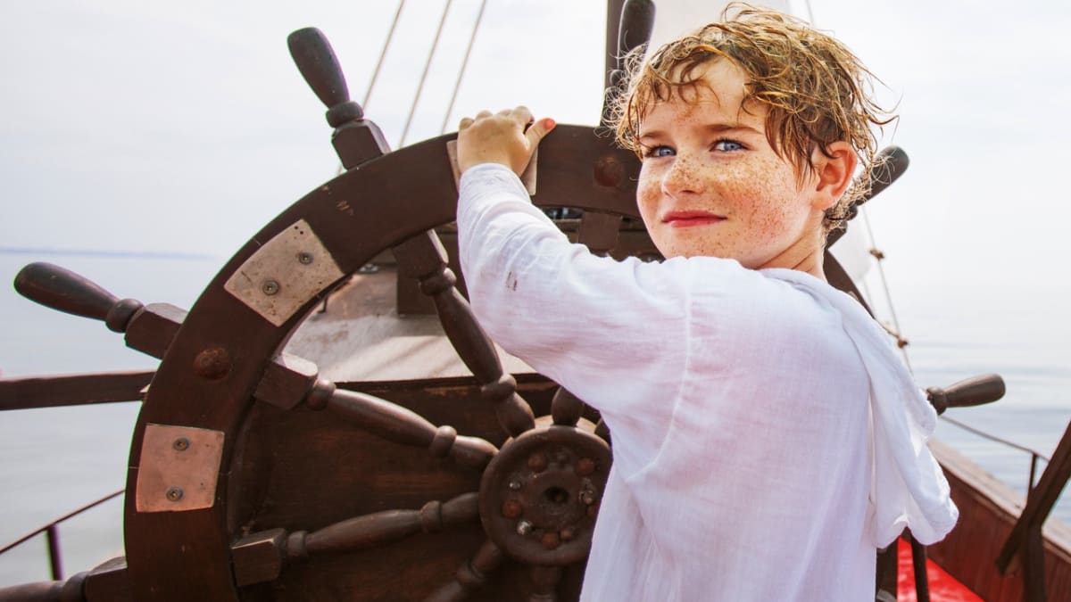 Young boy at the helm of a ship