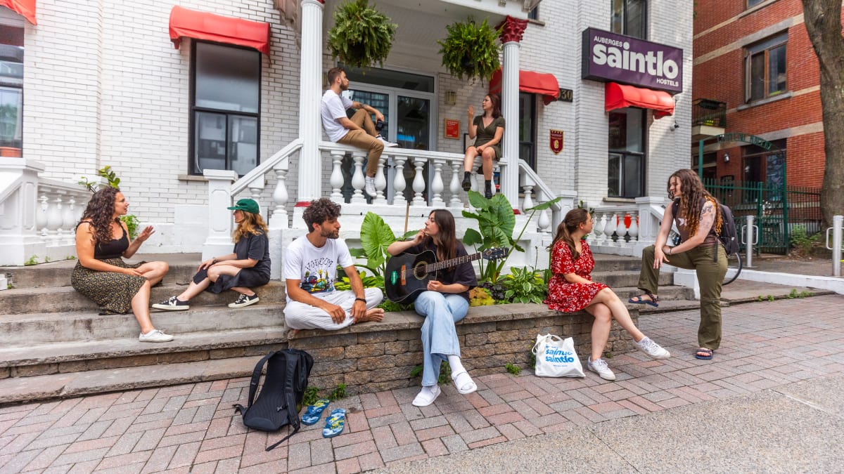 Groupe de voyageurs devant l'Auberge Saintlo Montréal.