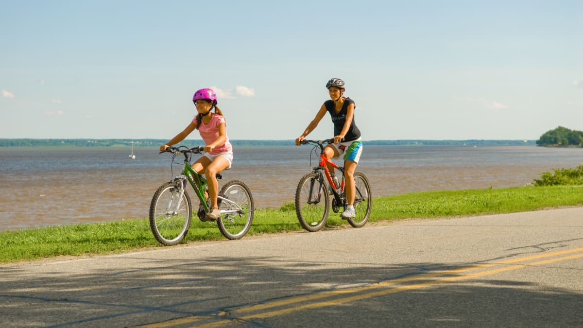 Women and girl on bikes by the water - Mauricie