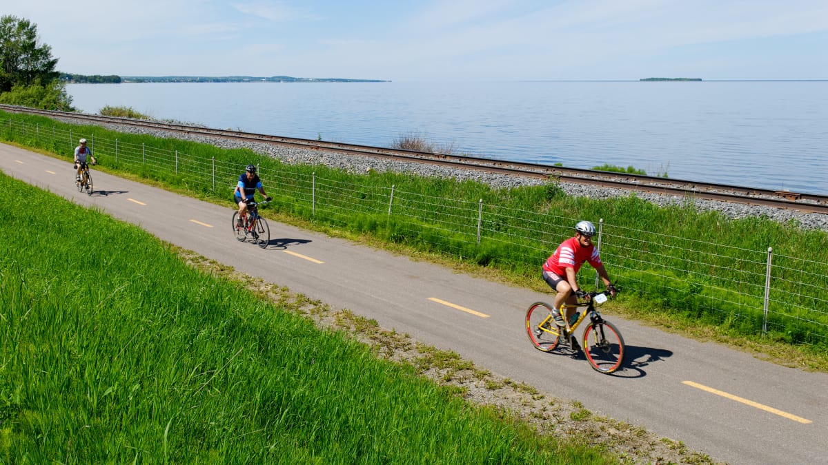 Three people on a bike path by the water