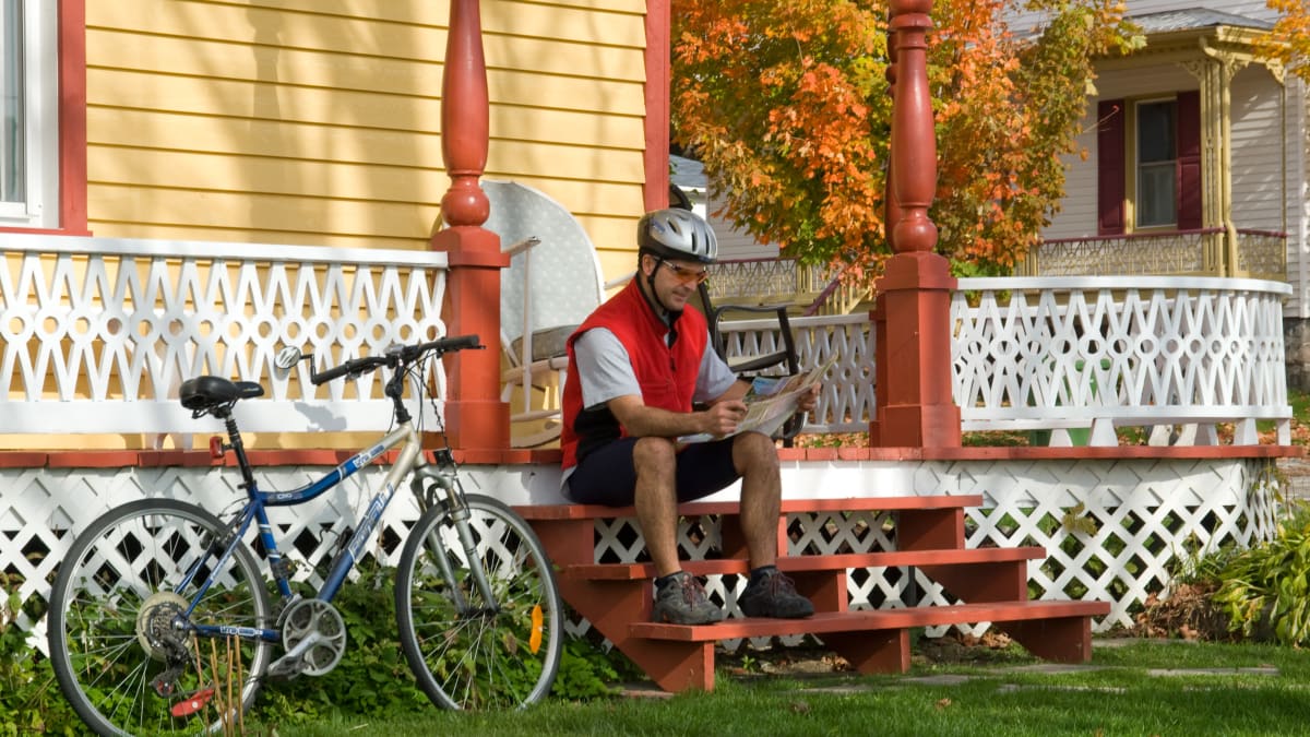 Homme assis sur un escalier en automne, son vélo à côté de lui
