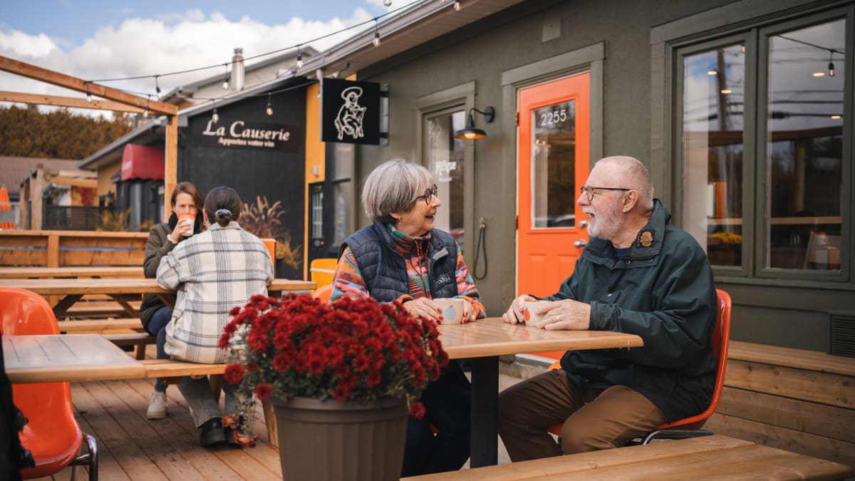 A few people sitting at tables on a café's patio