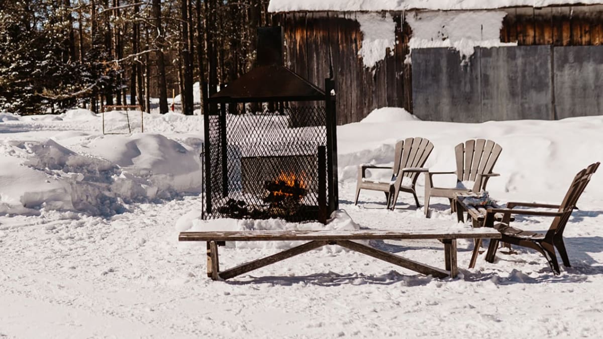 Outdoor fireplace in a snowy setting.