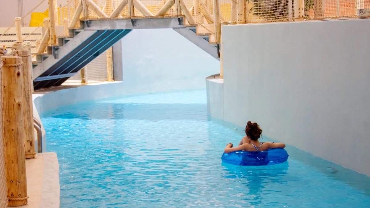 Une personne flotte dans l'eau au parc aquatique intérieur Oceania.