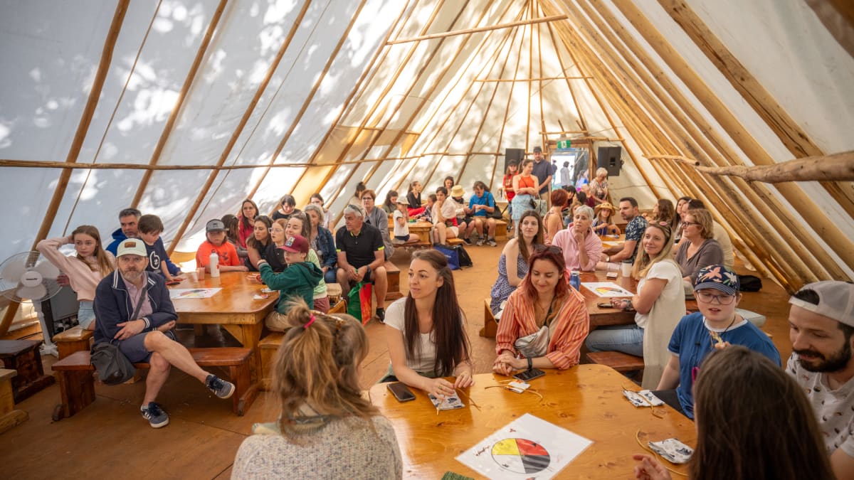 People inside a tipi at the KWE festival.