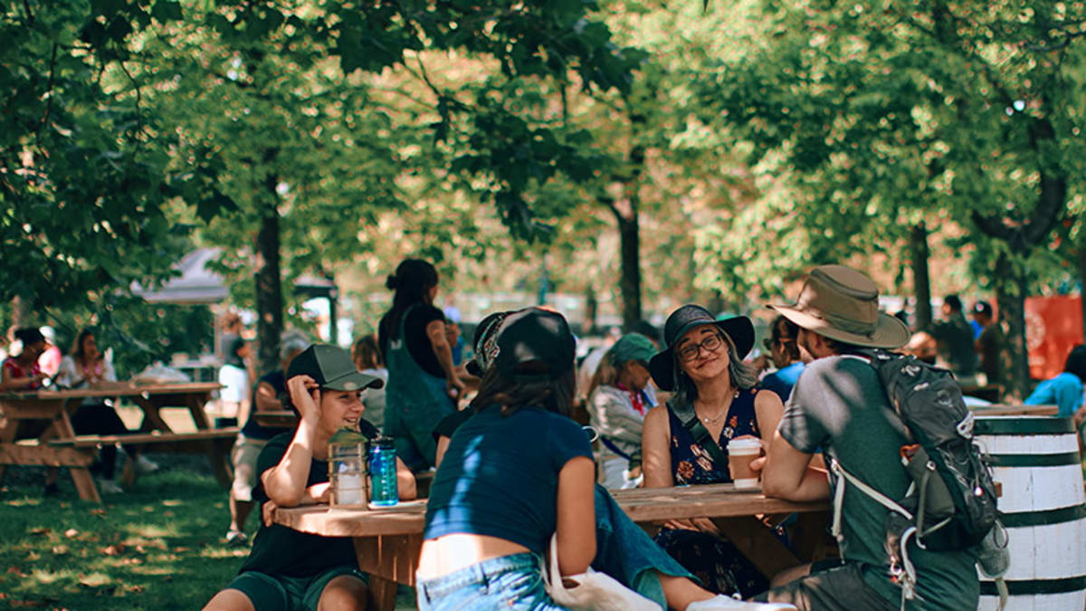 Group of people sitting at a picnic table during Les Rendez-vous gourmands