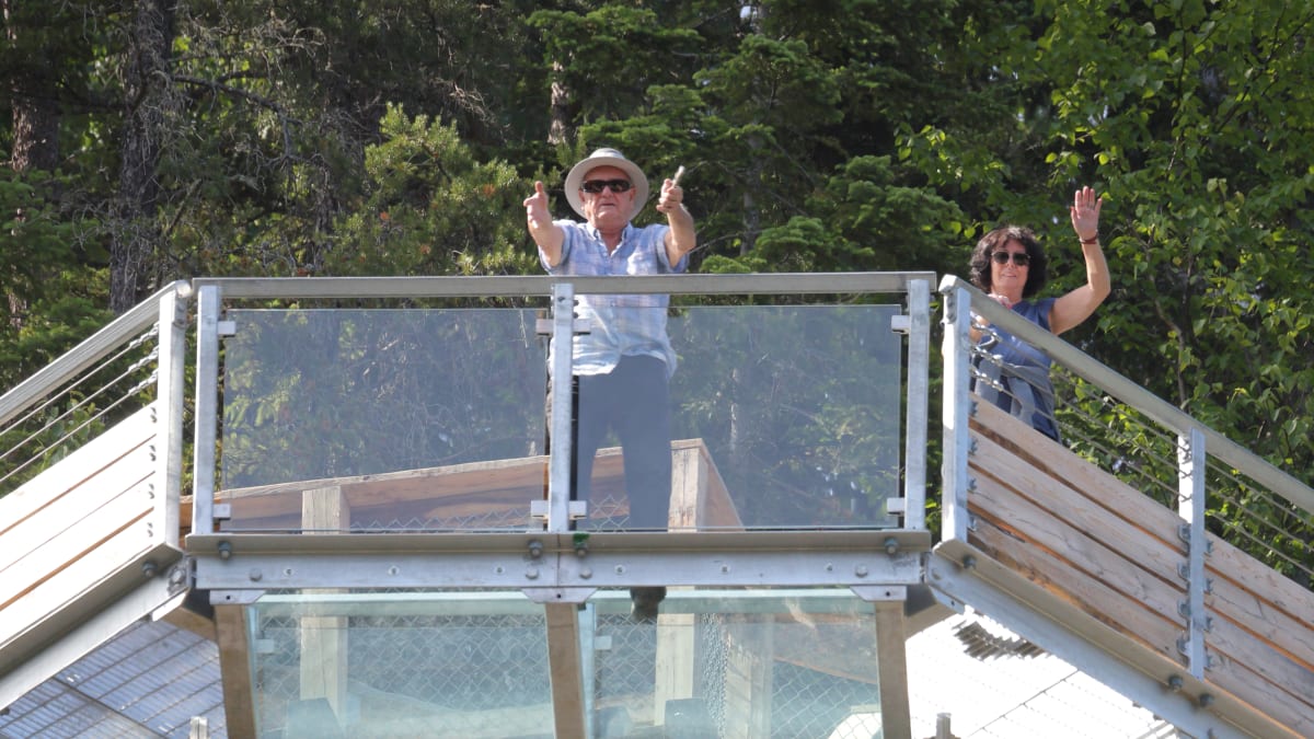 Deux visiteurs sur le plancher de verre au Parc le Trou de la Fée