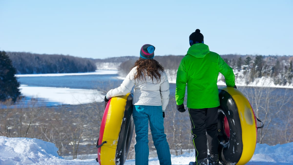 Two people with inner tubes in hand, contemplating the landscape.