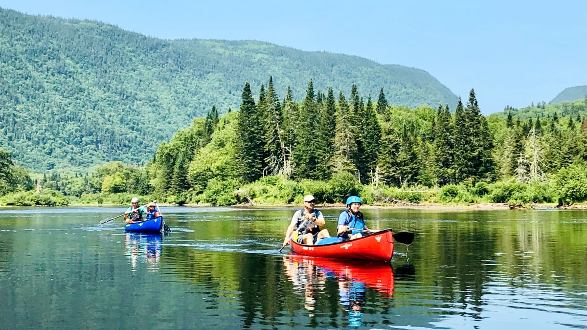 Deux couples dans deux canots sur le lac.