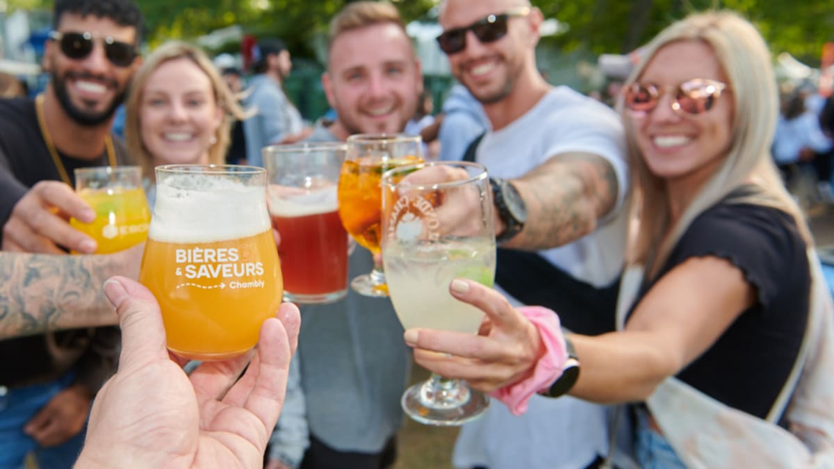 Group of smiling people clinking their glasses of beer.
