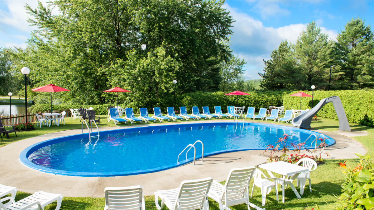 Outdoor in-ground pool surrounded by sun loungers.
