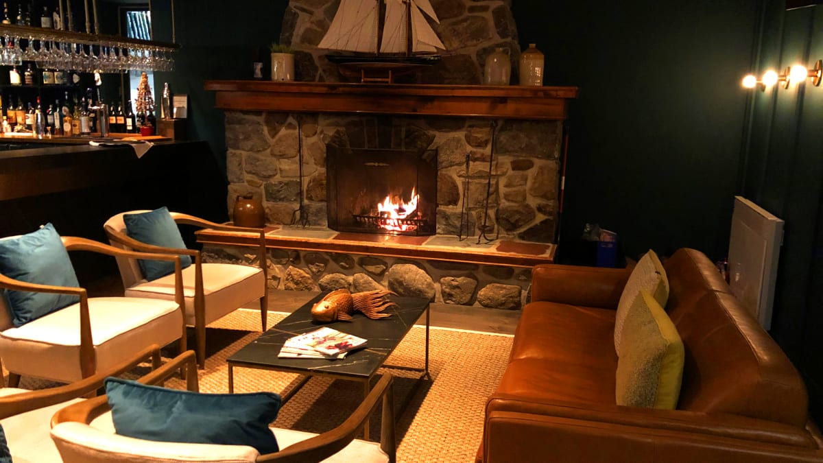 Lounge, bar, feu de foyer et sofas au Domaine Jolivent.