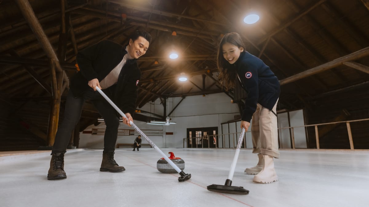 Two people playing curling.