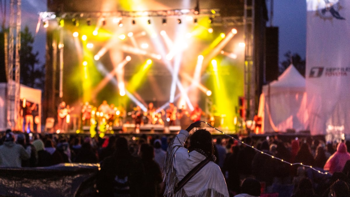 Scène illuminée avec spectacle en fin de soirée pendant le festival Innu Nikamu.
