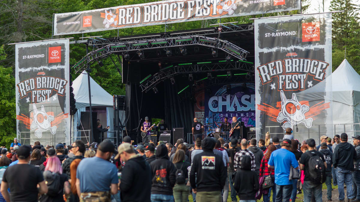 Crowd in front of a festival stage during the day.