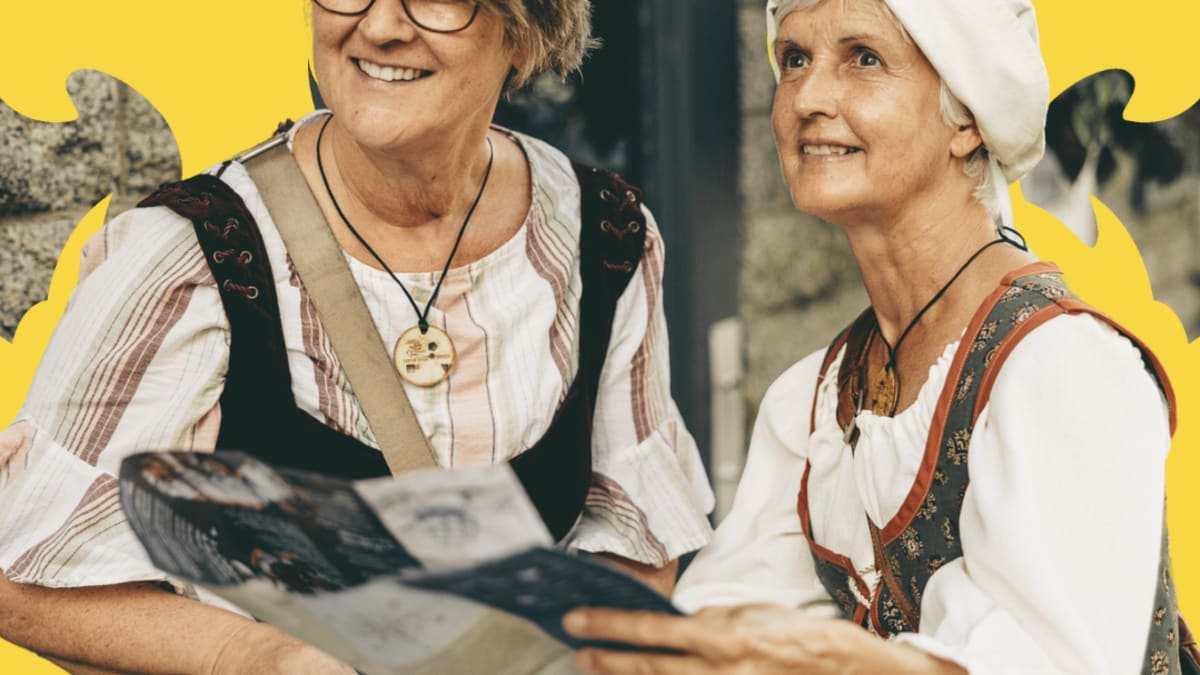 Two women in 17-century costumes taking part in a themed game.